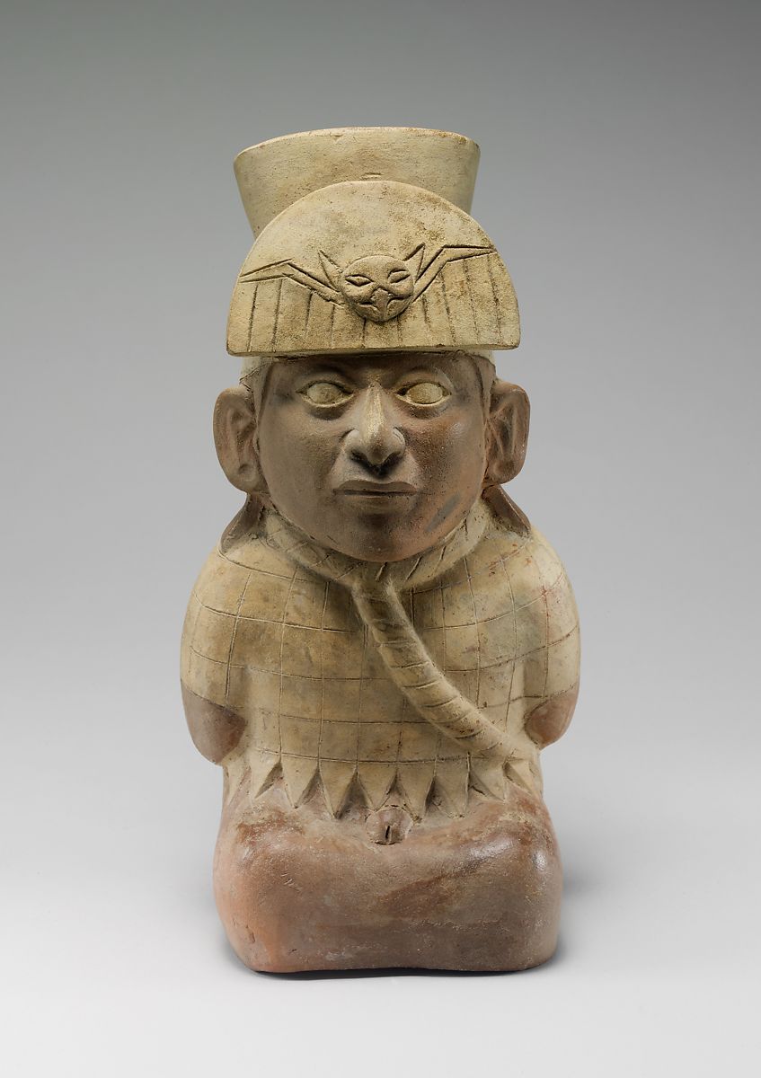 A Moche ceramic jar depicting a kneeling captive with bound neck and hands. His bonds, missing earspools, and exposed genitals are signs of defeat.